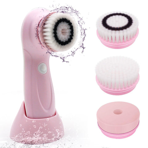 Pink facial cleansing brush with interchangeable heads on a white background