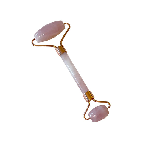 Rose quartz facial roller on a white background