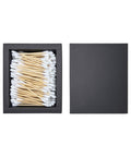 Black box with cotton swabs and wooden sticks on a white background