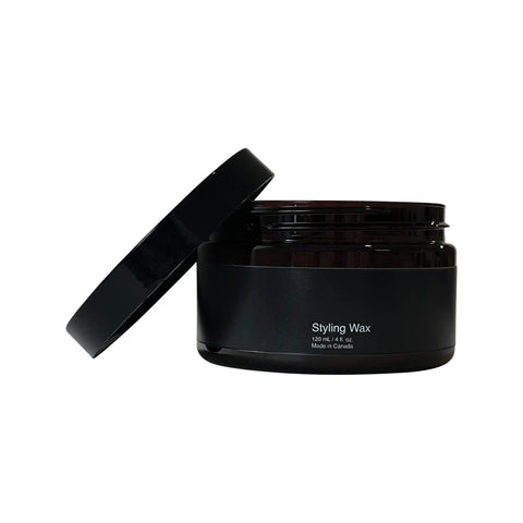 Black container of styling wax with open lid on a white background