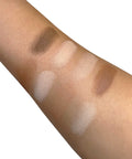 Eyeshadow swatches on a person's arm with various shades of brown and beige.