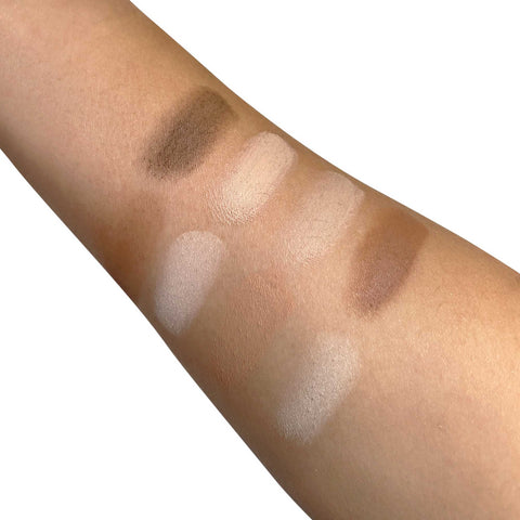 Eyeshadow swatches on a person's arm with various shades of brown and beige.
