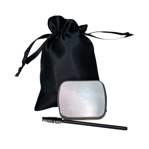 Silver makeup compact with black brush and black drawstring bag on a white background
