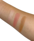 Three makeup swatches on a person's arm with different shades of pink and brown.