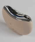 Beige hearing aid with metallic casing on a light gray background