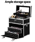 Black makeup storage case with multiple drawers and cosmetic items on a white background