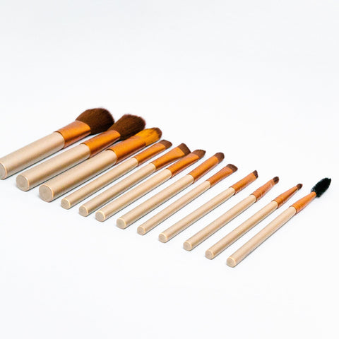 Set of makeup brushes with wooden handles on a white background