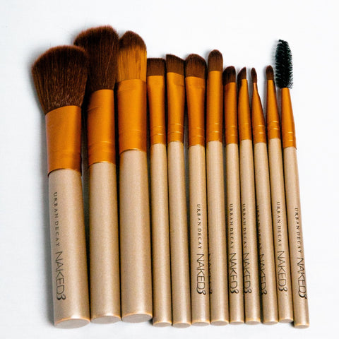 Set of makeup brushes with brown and beige handles on a white background