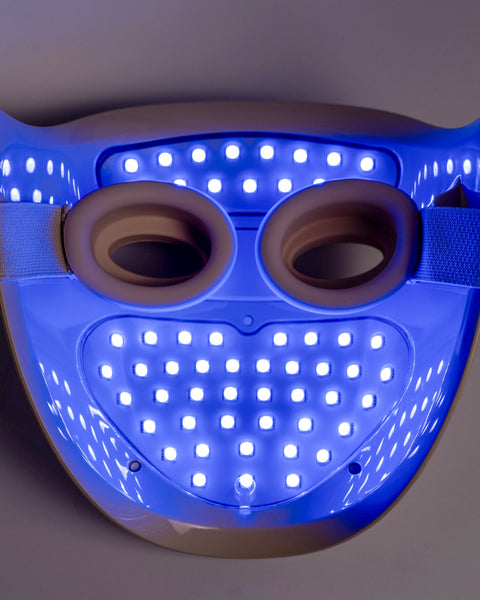 LED face mask with blue light on a gray background