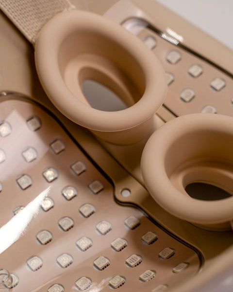 Close-up of a beige kitchen grater with two circular attachments on a white background.