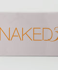 Makeup palette with 'NAKED3' text on a light gray background