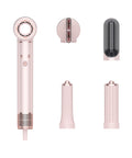 Set of pink hair styling tools including a hair dryer and attachments on a white background