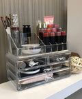 Clear acrylic cosmetic organizer with makeup items on a desk.