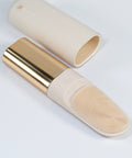 Makeup brush with gold and beige handle on a white background