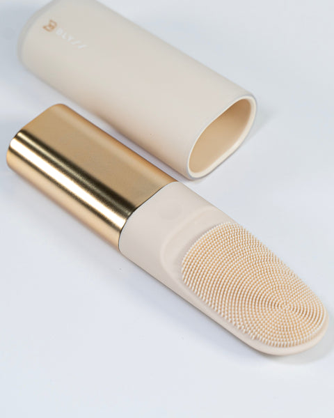 Makeup brush with gold and beige handle on a white background